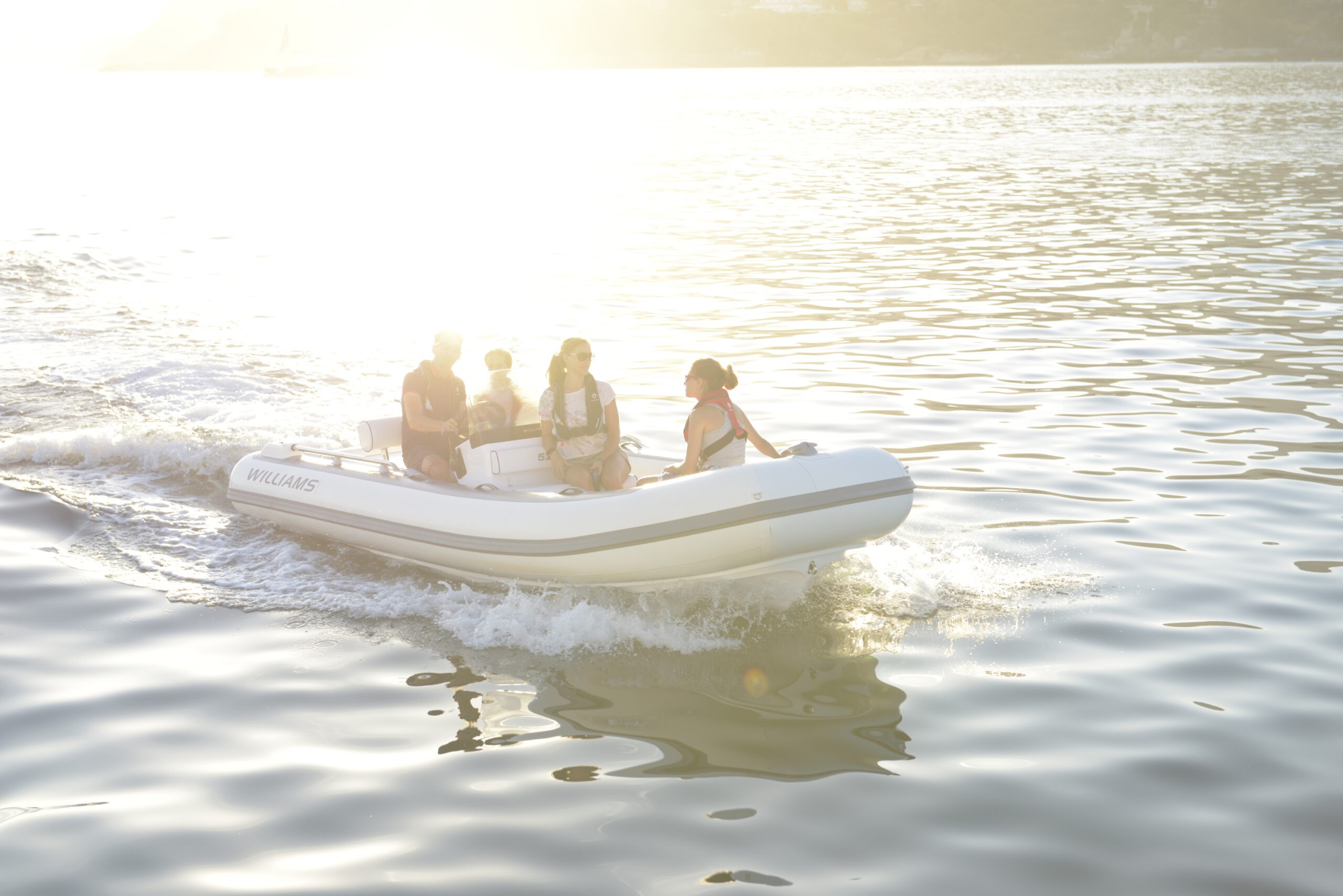 Guests unwind aboard a premium yacht tender, surrounded by calm seas and golden sunlight.