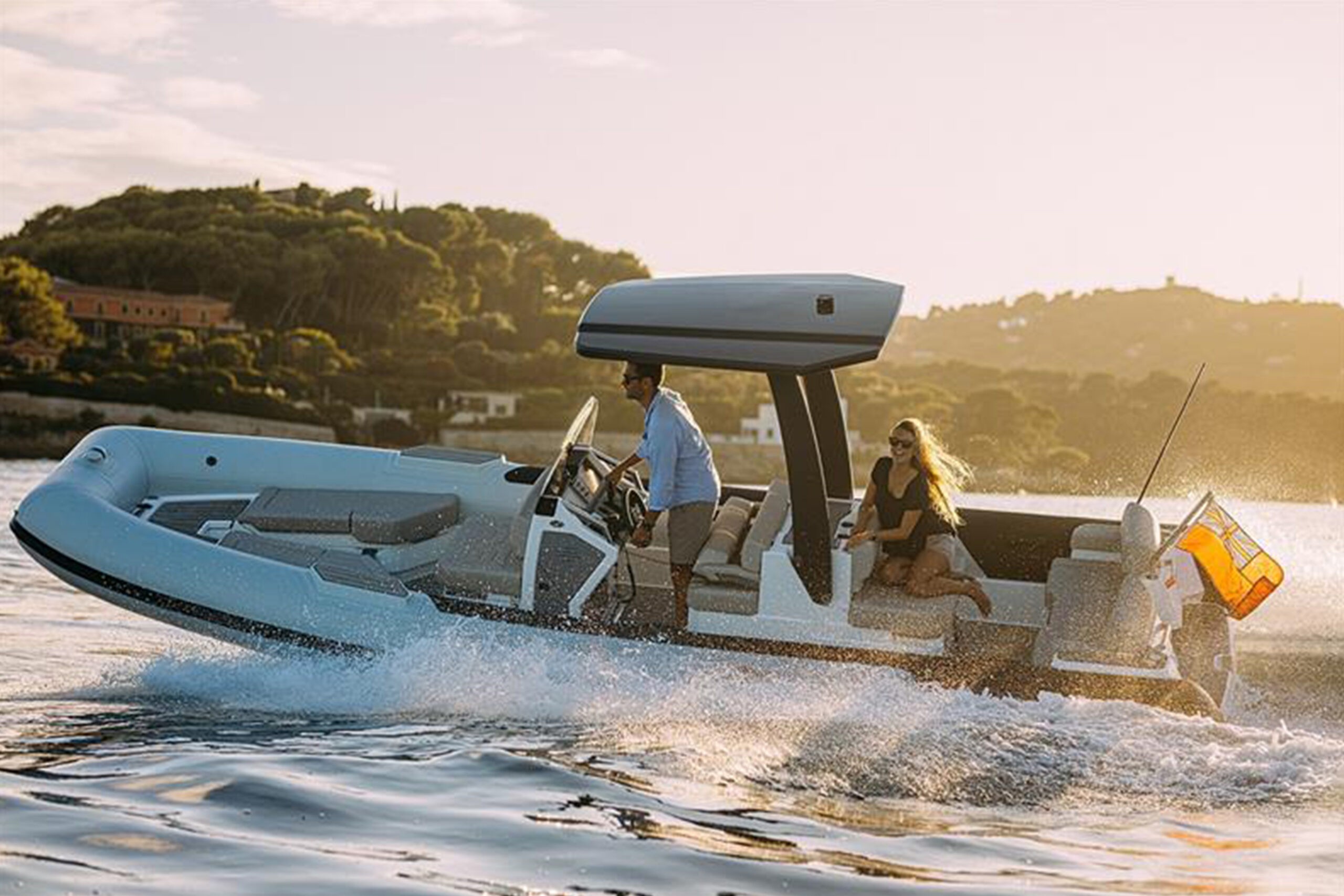 A man and woman enjoying a ride on a Williams lightweight tender at sunset.