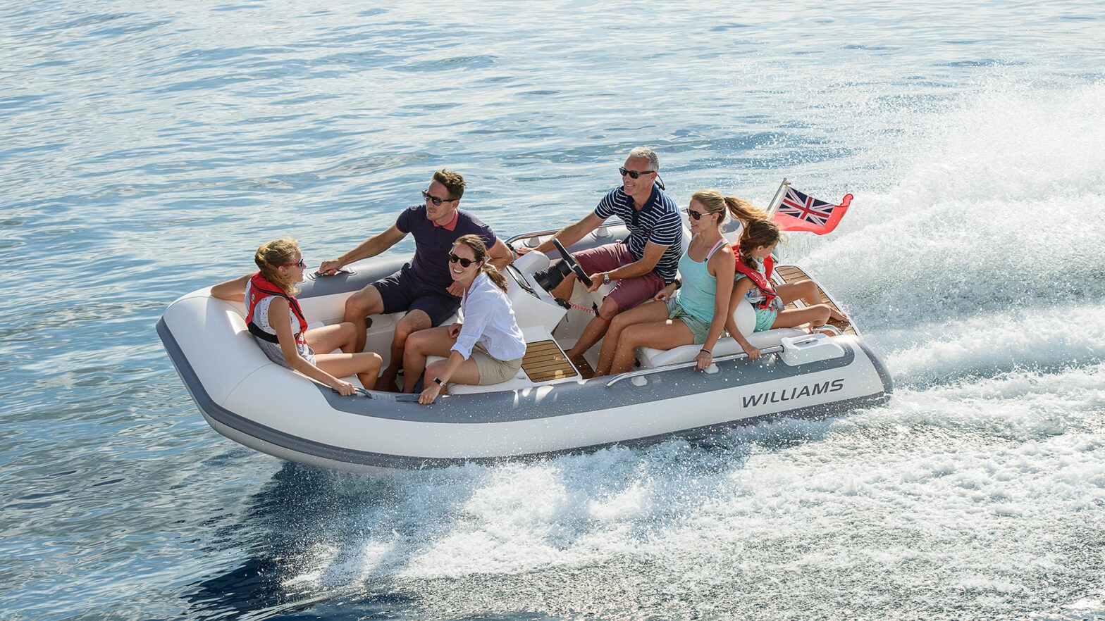 A group of people enjoying a ride in a Williams midsized yacht tenders on the water.
