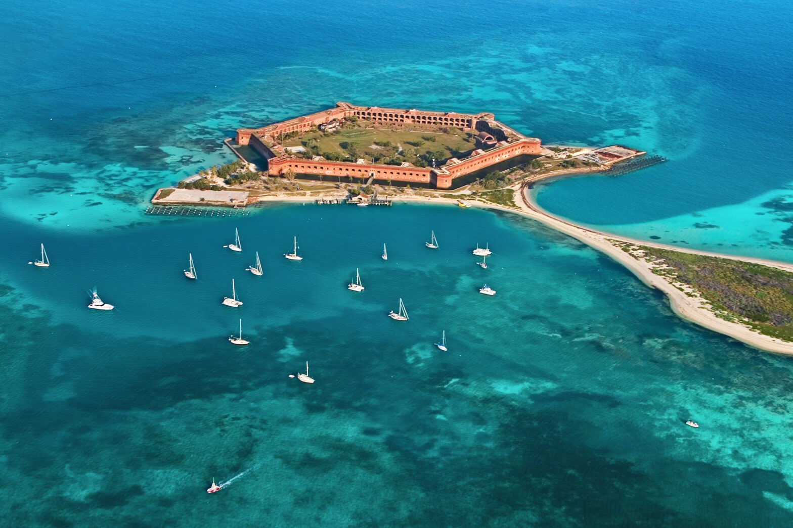 Aerial view of Fort Jefferson in Dry Tortugas with sailboats in turquoise waters.